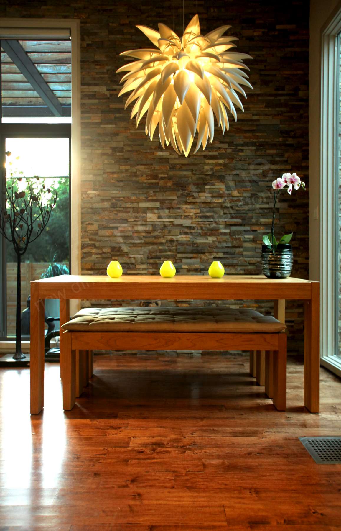 Norstone Ochre Rock Panels serving as a background feature wall in a small corner dining area with a spectacular sunburst syle overhead light fixture